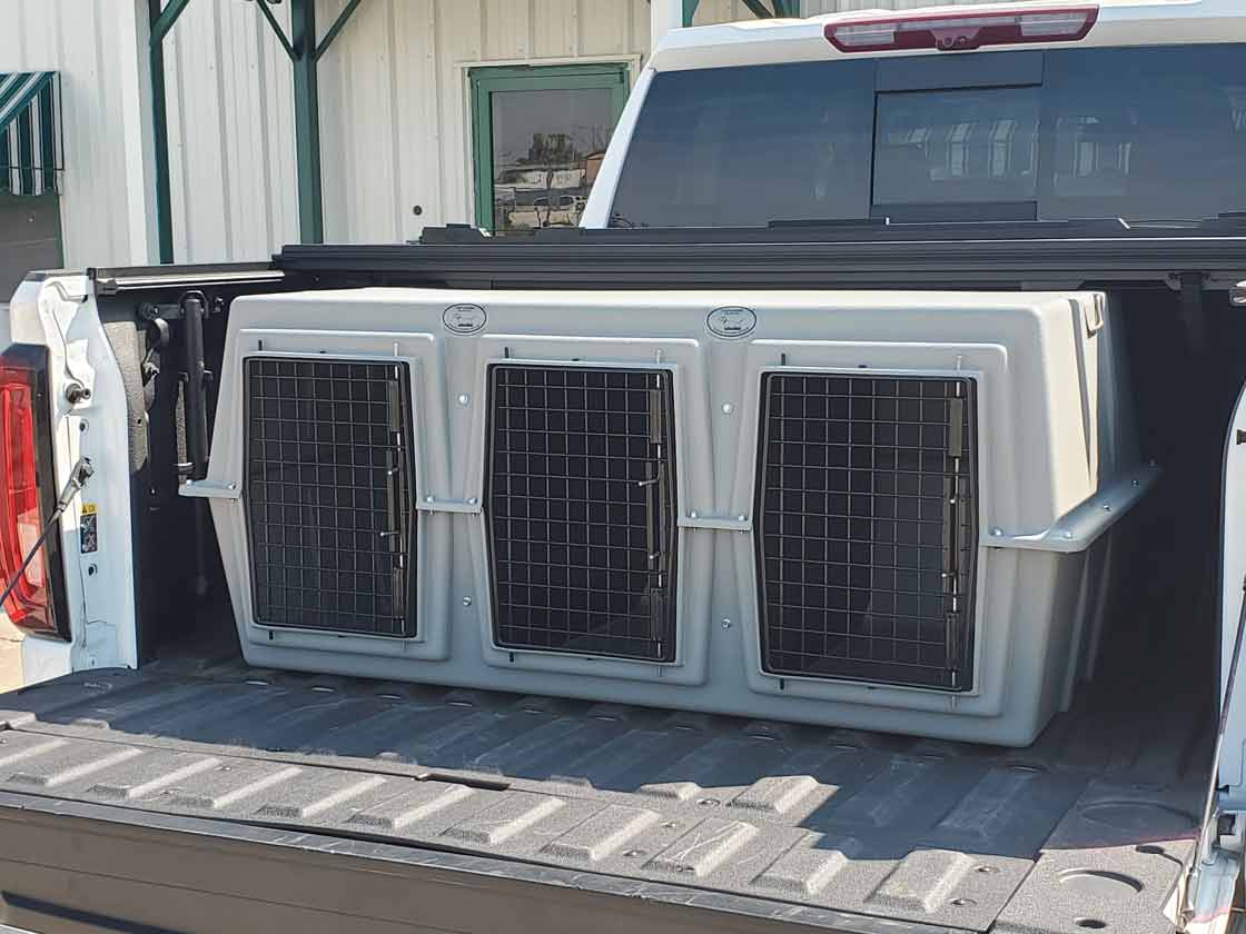 Easy Loader Three Hole Kennel loaded into a pickup truck bed.